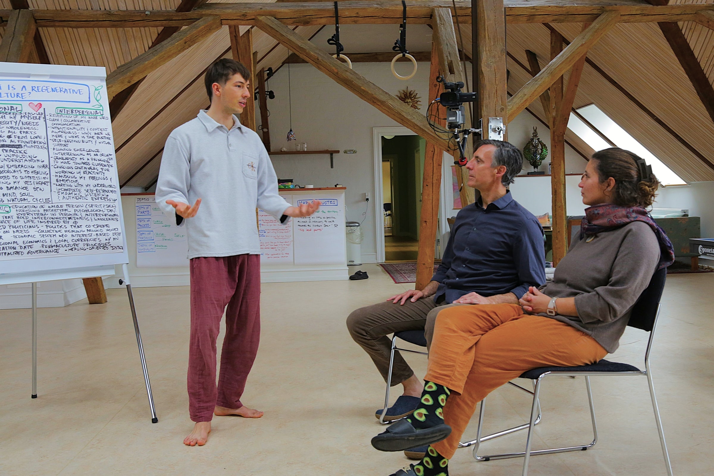 A participant presenting to two seated listeners during a Regenera session
